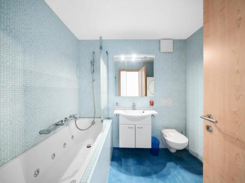 a bathroom with a tub and a sink and a toilet at Apartment Apt C4-R - Résidence Bougainville by Interhome in Bouveret