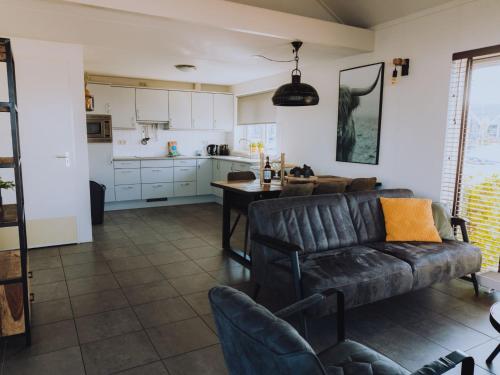 a living room with a couch and a table at Holiday Home Kraaijennest by Interhome in Uitgeest
