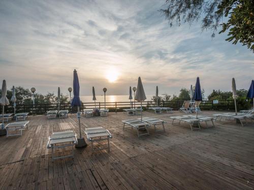 a group of lounge chairs and umbrellas on a deck at Holiday Home Miramare-3 by Interhome in Antignano