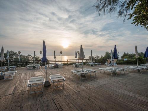 a group of lounge chairs and umbrellas on a deck at Holiday Home Miramare-1 by Interhome in Antignano