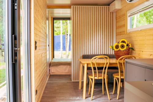 a tiny house with a dining room with a table and chairs at Arche Siedlisko Augustynka 59 