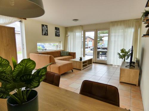 un soggiorno con tavolo e divano di Holiday Home De Meerparel-1 by Interhome a Uitgeest