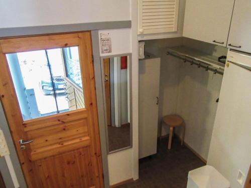 uma pequena cozinha com uma porta de madeira e uma mesa em Holiday Home Kelokivakka d19 by Interhome em Ruka