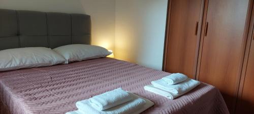 Un dormitorio con una cama con toallas. en Apartment Anita Novalja, en Novalja