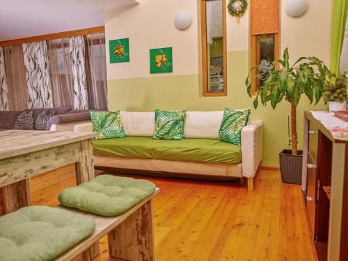 a living room with a green couch and wooden floors at Apartment Neugasteig-1 by Interhome in Neustift im Stubaital