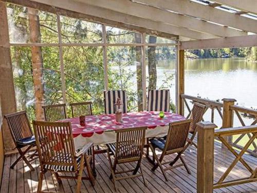 een tafel en stoelen op een terras met uitzicht op een meer bij Holiday Home Lövkulla by Interhome in Löparö