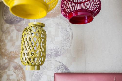 two yellow and red lights hanging from a ceiling at Diamante MHotel in Collegno