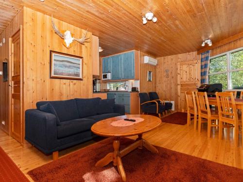 ein Wohnzimmer mit einem blauen Sofa und einem Tisch in der Unterkunft Holiday Home Valkeisrinne 1h by Interhome in Ruka