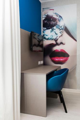 a desk with a picture of a woman with red lips at Diamante MHotel in Collegno