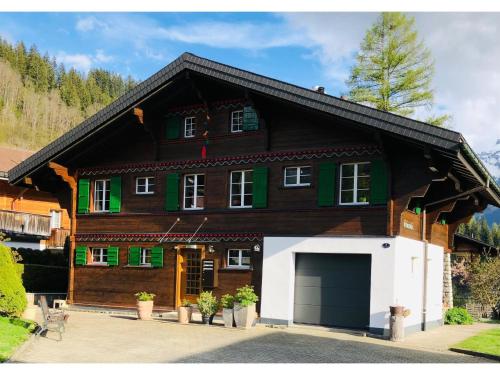 a large wooden house with a garage at Apartment Träumli by Interhome in Lenk