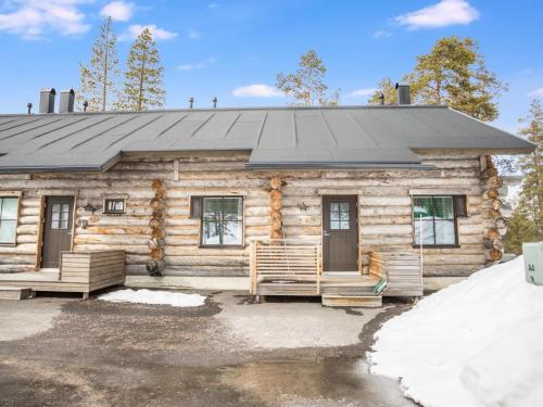 uma cabana de madeira com um telhado preto em Holiday Home Maahisenrinne 1 as 4 by Interhome em Äkäslompolo