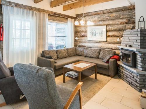 a living room with a couch and a fireplace at Holiday Home Maahisenrinne 1 as 4 by Interhome in Äkäslompolo