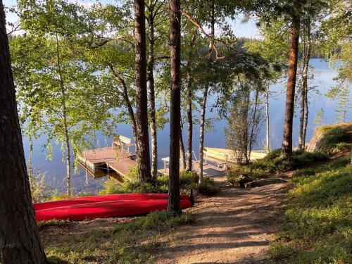 una canoa roja al lado de una carretera junto a un lago en Holiday Home Hiawatha by Interhome, en Auttoinen