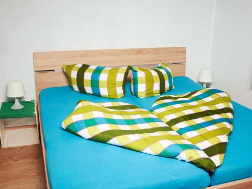 a blue bed with two pillows on top of it at Apartment Neugasteig-3 by Interhome in Gasteig