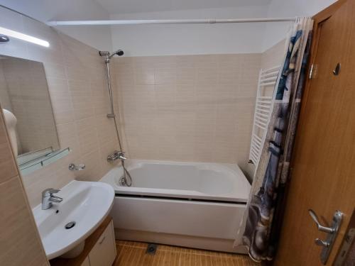 a bathroom with a white tub and a sink at Borovets Semiramida Garden Studio A16 in Borovets