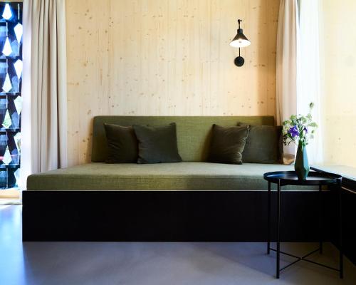 ein grünes Sofa in einem Zimmer mit Tisch in der Unterkunft KOKON Apartments in Leutasch