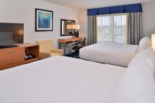 a hotel room with two beds and a desk and a television at Holiday Inn Express and Suites West Ocean City by IHG in Ocean City