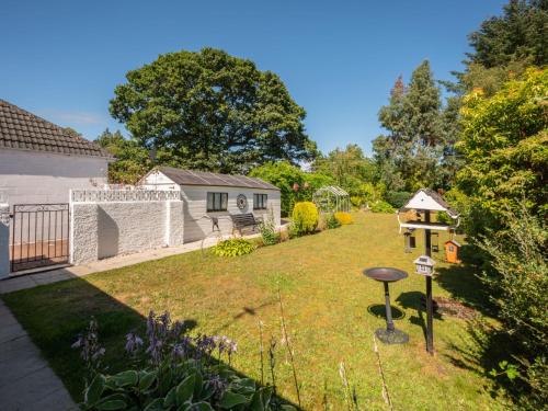 un cortile con una casa e un giardino con una casetta per gli uccelli di Holiday Home Broom Park by Interhome a Inverness