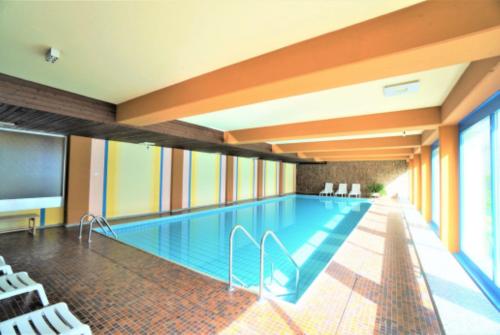 basen w budynku z telewizorem w obiekcie Lovely 1-bedroom vacation studio apartment with pool and sauna w mieście Laax