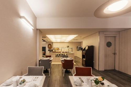 a dining room with tables and chairs and a kitchen at Hotel Marques De Pombal in Lisbon