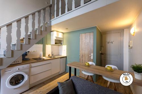 kuchnia ze stołem i schodami w pokoju w obiekcie Le P'ti Pau - Centre de Pau - Appartement lit double w mieście Pau