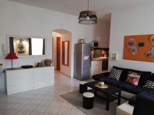 a living room with a couch and a kitchen at Orange: appartement pratique et idéalement placé in Orange