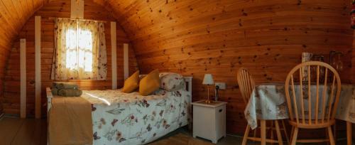 a bedroom with a bed in a wooden cabin at Glamping in Wiltshire the Green Knoll is a charm in Chippenham