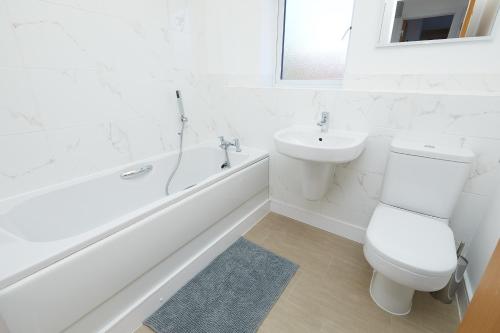 a white bathroom with a toilet and a sink at Royal Derby Hospital Luxury House in Derby