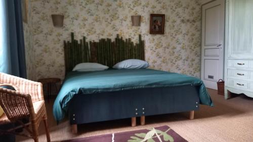 a bedroom with a bed with a blue comforter at La Palombiere in Lucmau