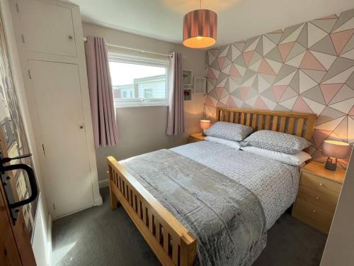 - une chambre avec un grand lit et une fenêtre dans l'établissement 5 Hemsby Holiday Chalet, Convenient for sandy beach, à Hemsby