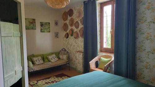 a bedroom with a bed and a chair and a window at La Palombiere in Lucmau
