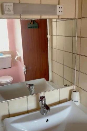 a bathroom with a sink and a mirror at 2 Bedroom Holiday Apartment Skegness - Flat 18 in Skegness