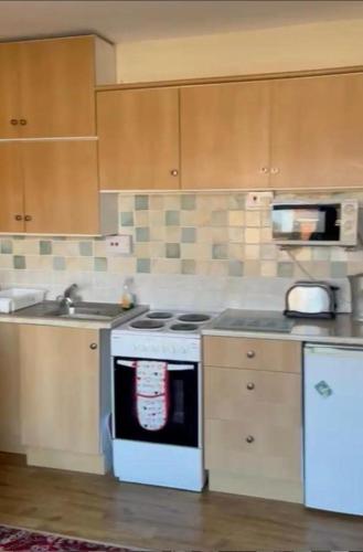 a kitchen with a white stove and a sink at 2 Bedroom Holiday Apartment Skegness - Flat 18 in Skegness