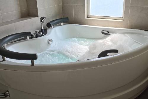 a bath tub filled with lots of water at KLCC Amazing Robots Homestay 4Bedrooms (13pax) in Kuala Lumpur