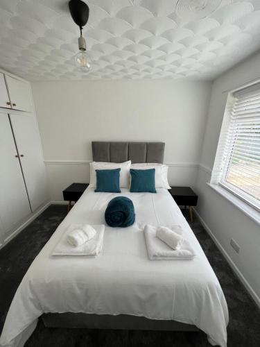 a bedroom with a large white bed with blue pillows at Serene Property Next to Southampton General Hospital in Southampton