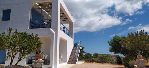 Casa blanca con balcón y árboles en Theros house, en Citera
