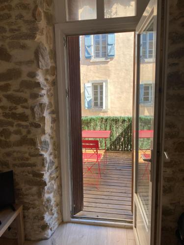 une porte coulissante en verre menant à une terrasse avec une table. dans l'établissement Au cœur de Carcassonne, à Carcassonne