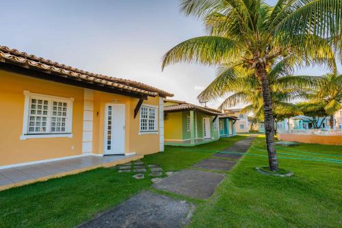 a palm tree in front of a row of houses at Chalé Mares in Estância