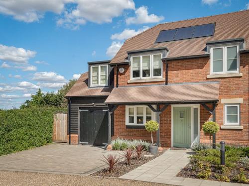 a brick house with solar panels on the roof at Delightful 3 Bed Country home with Large Garden in Abbots Langley