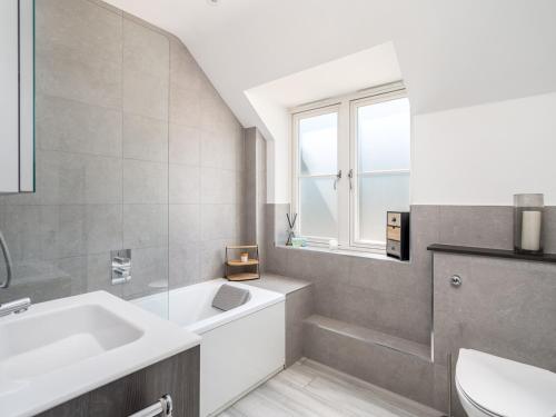 a bathroom with a sink and a tub and a window at Delightful 3 Bed Country home with Large Garden in Abbots Langley