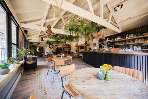 a restaurant with a table and chairs and a bar at Sandberghe - Een plek om te verdwalen in Uden