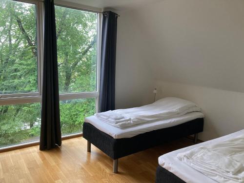 sypialnia z 2 łóżkami i dużym oknem w obiekcie Parken Terrasse Apartment Hotel w mieście Kopervik