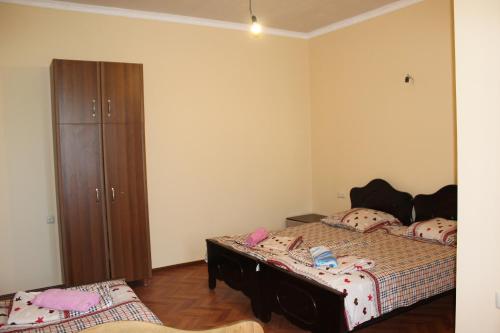 a bedroom with two beds and a dresser at Guest House Gela in Batumi