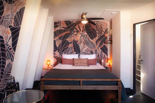 1 dormitorio con 1 cama con un mural en la pared en Zwanestein Canal House, en Ámsterdam