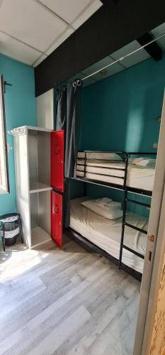 Habitación con 2 literas y armario rojo. en GREEN Hostel MADRID GRAN VIA, en Madrid