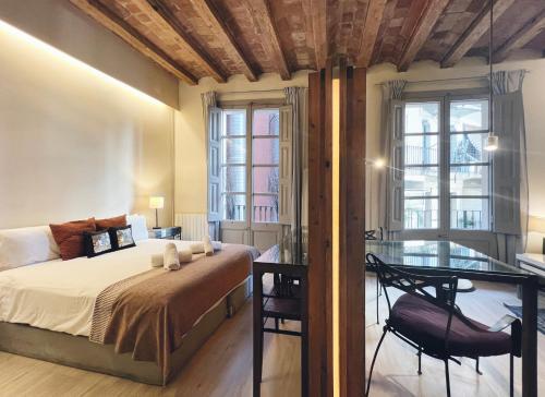 1 dormitorio con 1 cama, escritorio y ventanas en Plaza Catalunya IX Apartment, en Barcelona