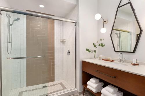 W łazience znajduje się prysznic i umywalka. w obiekcie Hotel Indigo - Winston-Salem Downtown, an IHG Hotel w mieście Winston-Salem