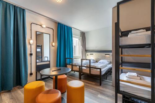 Zimmer mit 2 Etagenbetten sowie einem Tisch und Stühlen in der Unterkunft a&o Frankfurt Ostend in Frankfurt am Main