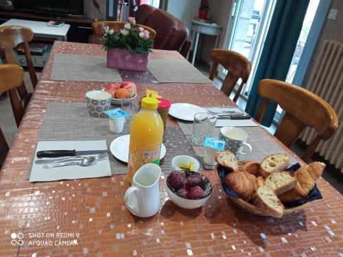 un tavolo con prodotti per la colazione e una bottiglia di succo d'arancia di LA PETITE MEUNIERE 