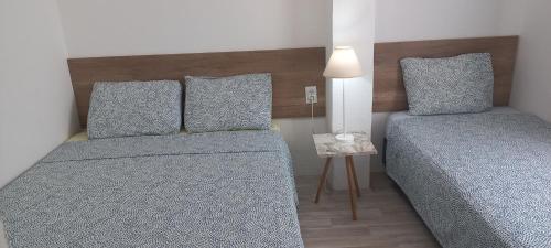 a small bedroom with two beds and a table at Happiness Apartment Center in Bitola